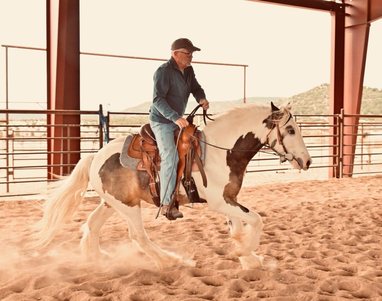 Man riding a horse in a dusty arena.