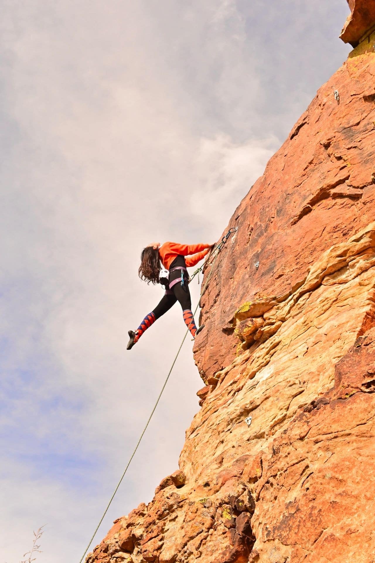 Person rock climbing on steep cliff.