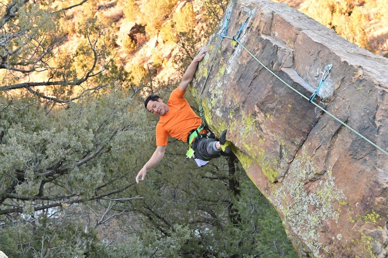 Climber dangling from rock face outdoors