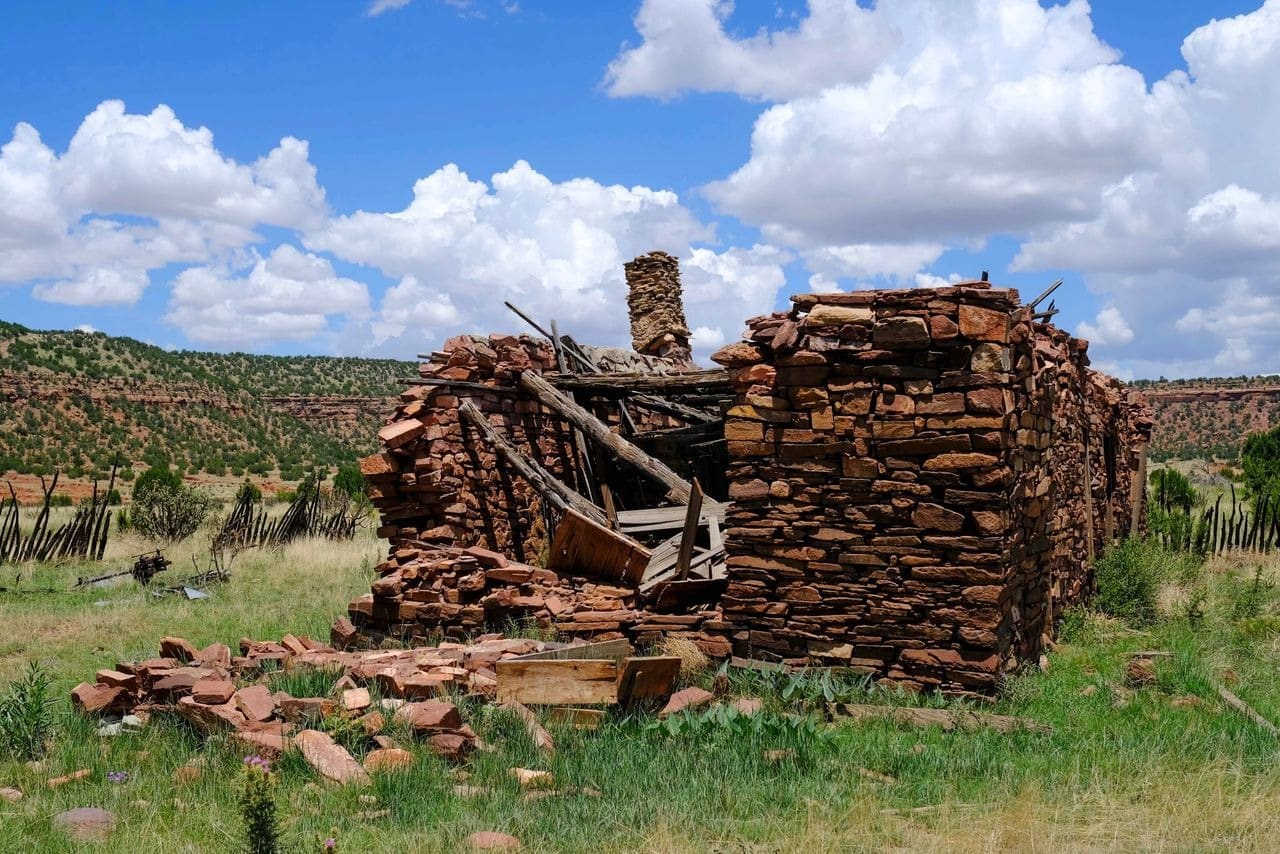 Ruined stone building, desert landscape, blue sky.