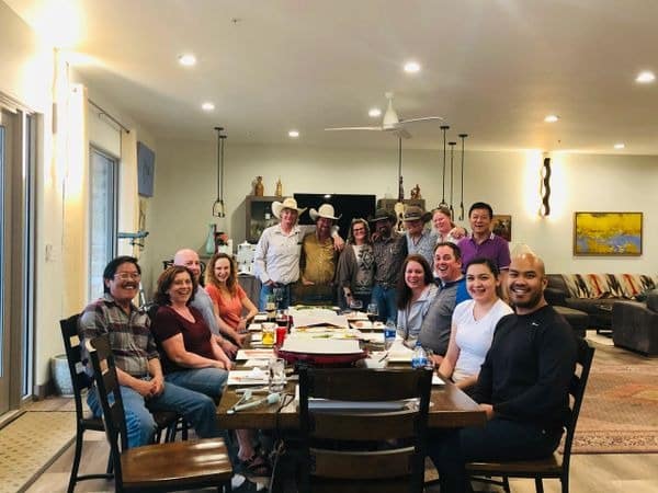 Group of people smiling around a dining table.